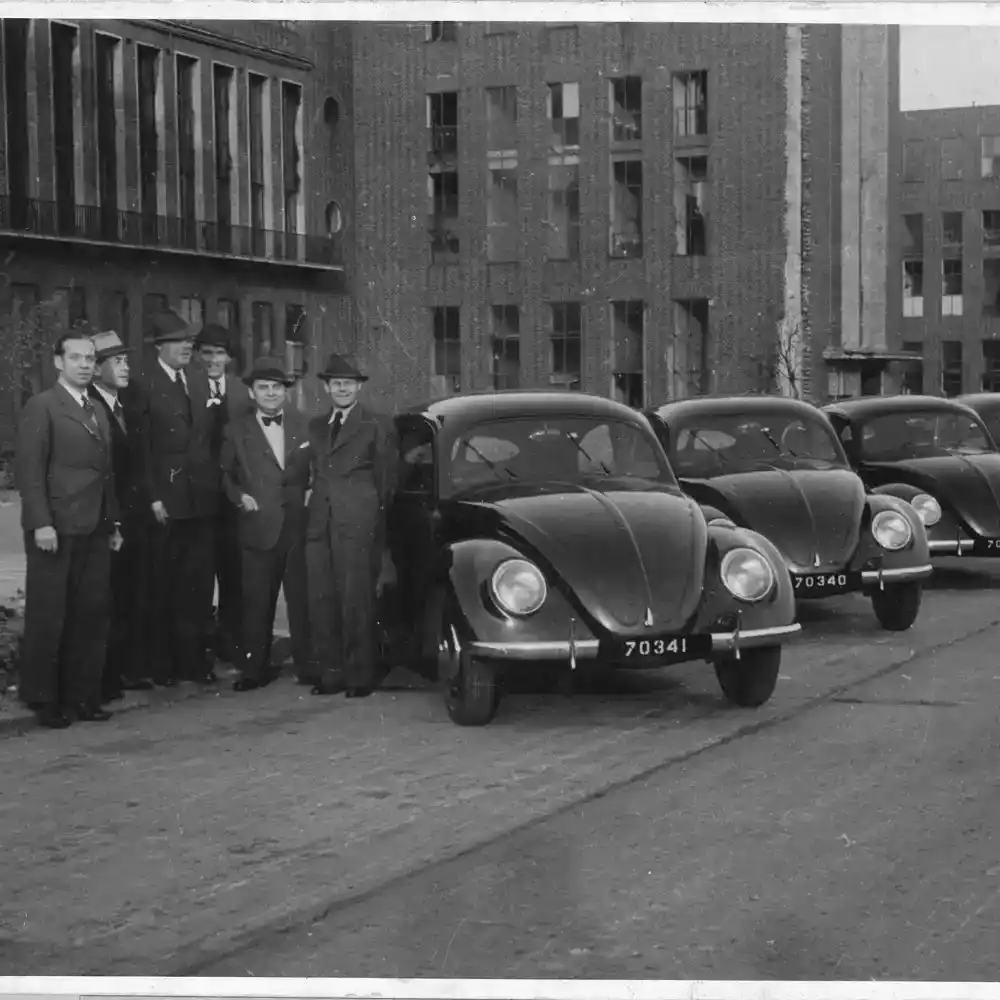 mannen staan bij oude kevers